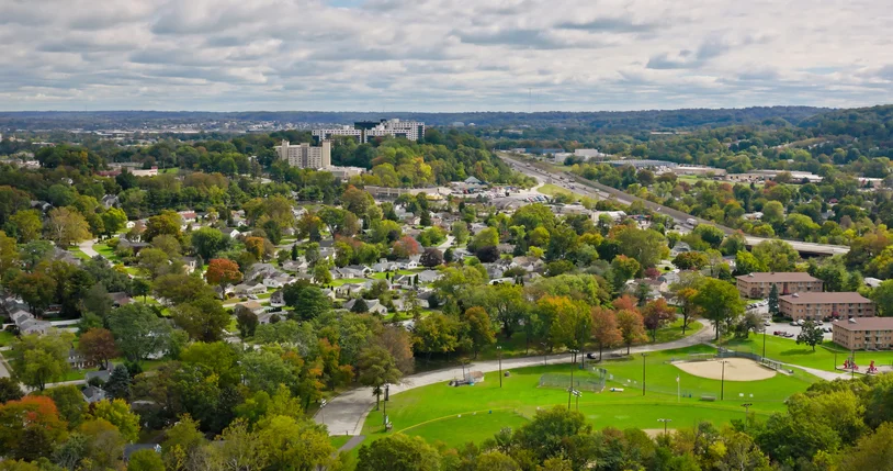 Aerial view of a tree-lined Montgomery County, Pennsylvania township with a creek corridor and borough main street