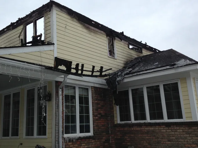 Charred roofline and burned second-story siding on a Pennsylvania home after a residential fire