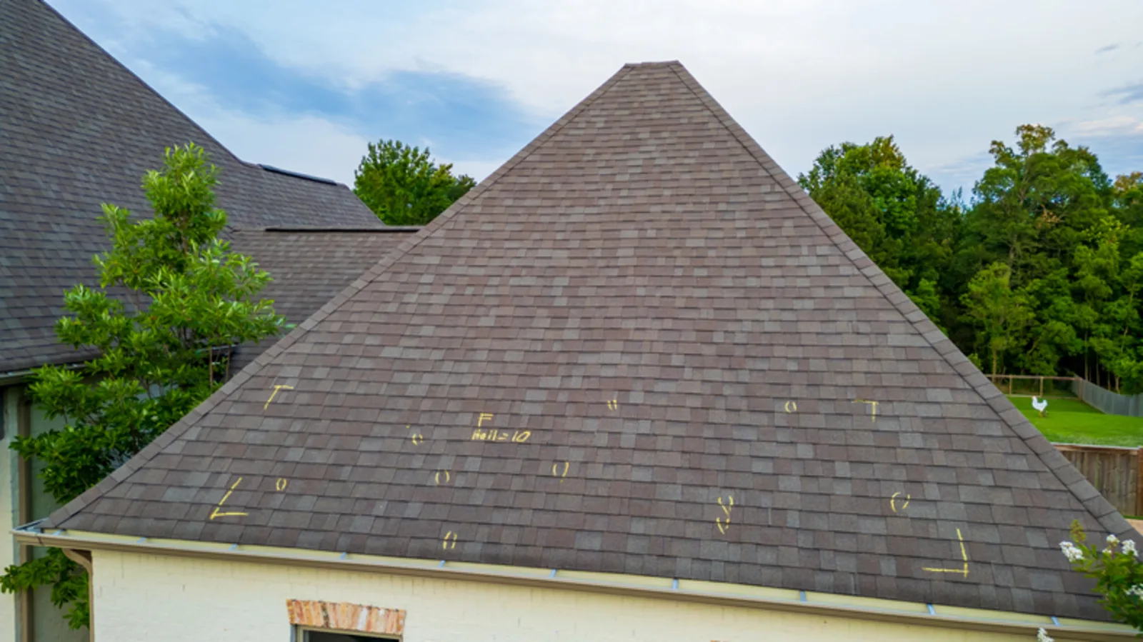 Hip roof marked with chalk test square measurements and hail hit counts during a Pennsylvania hail damage roof inspection