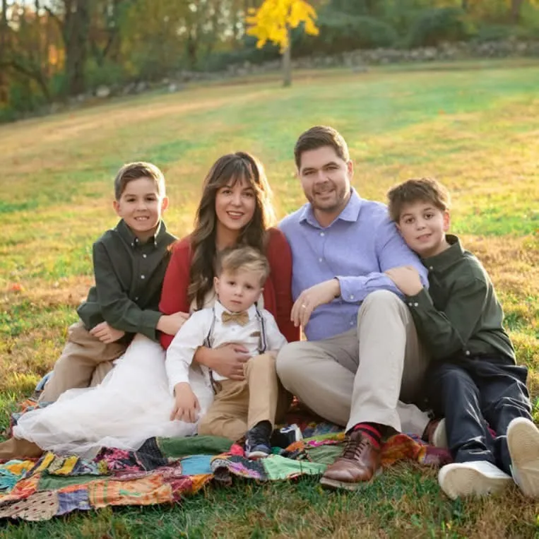 The Krail family, owners of Legacy Public Adjusters, seated on a quilt in a Chester County field